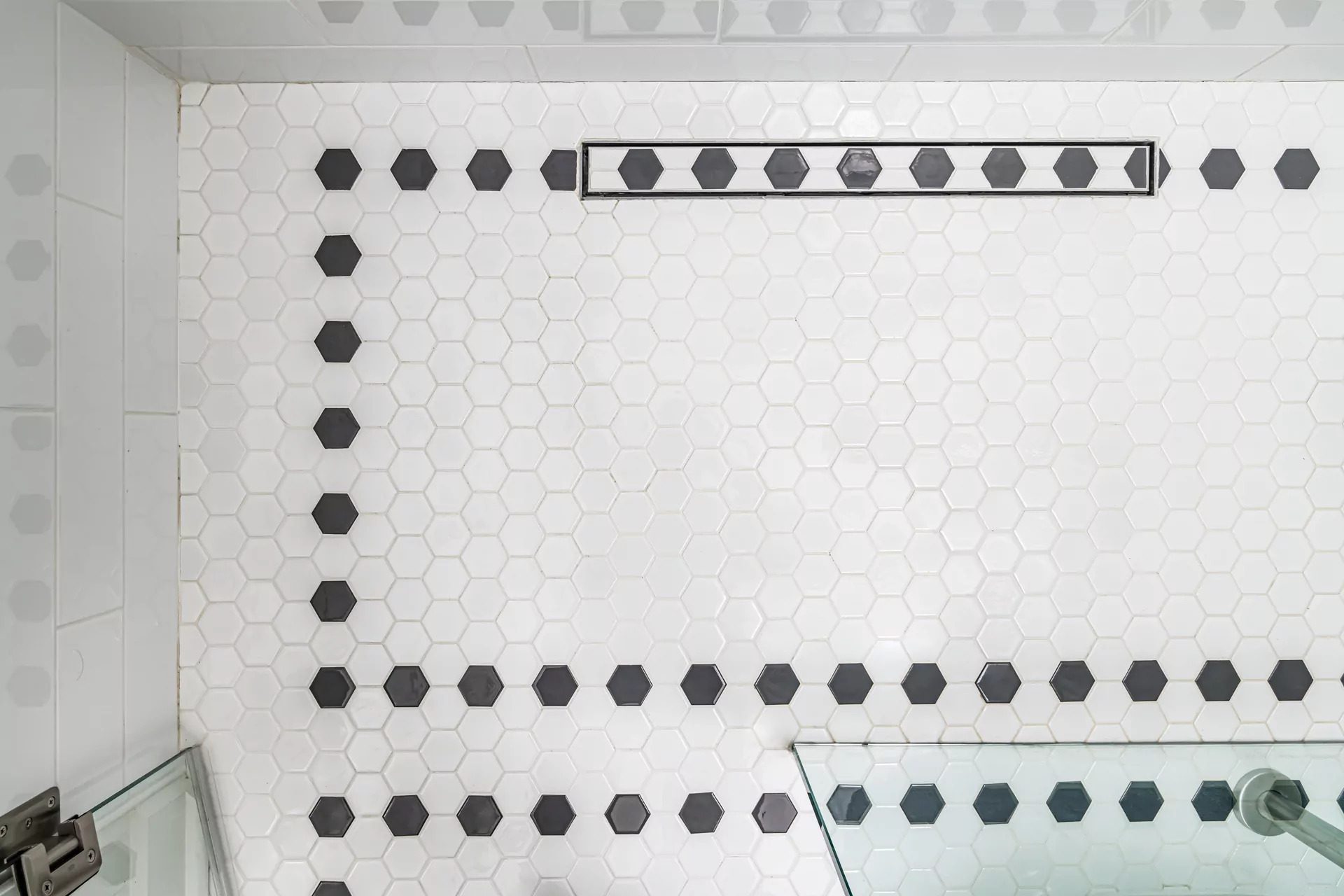 Black and white hexagon shower floor with a linear drain set into the pattern, Toronto