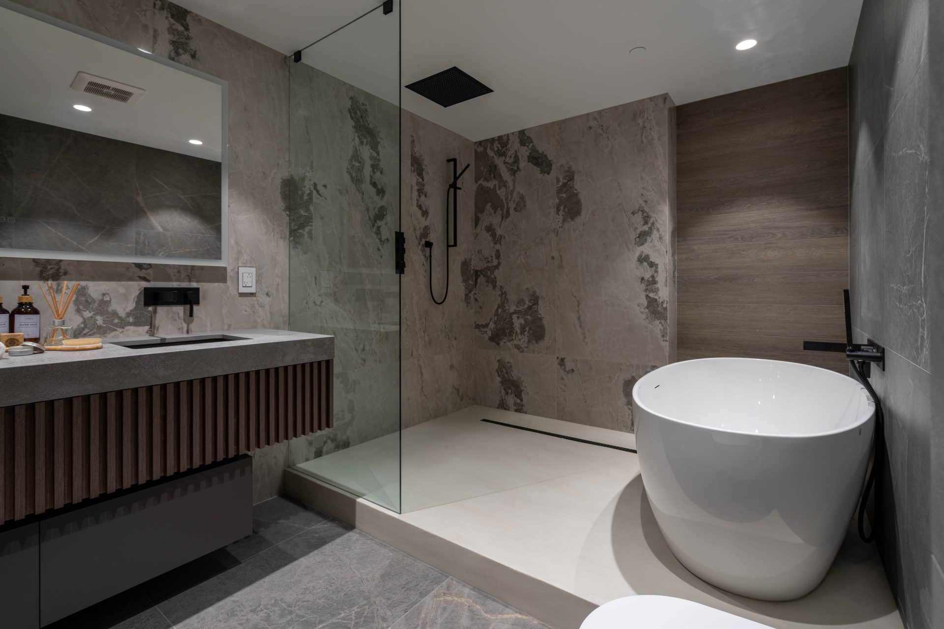 Walk-in glass shower and floating vanity in stone-look porcelain, Toronto ensuite