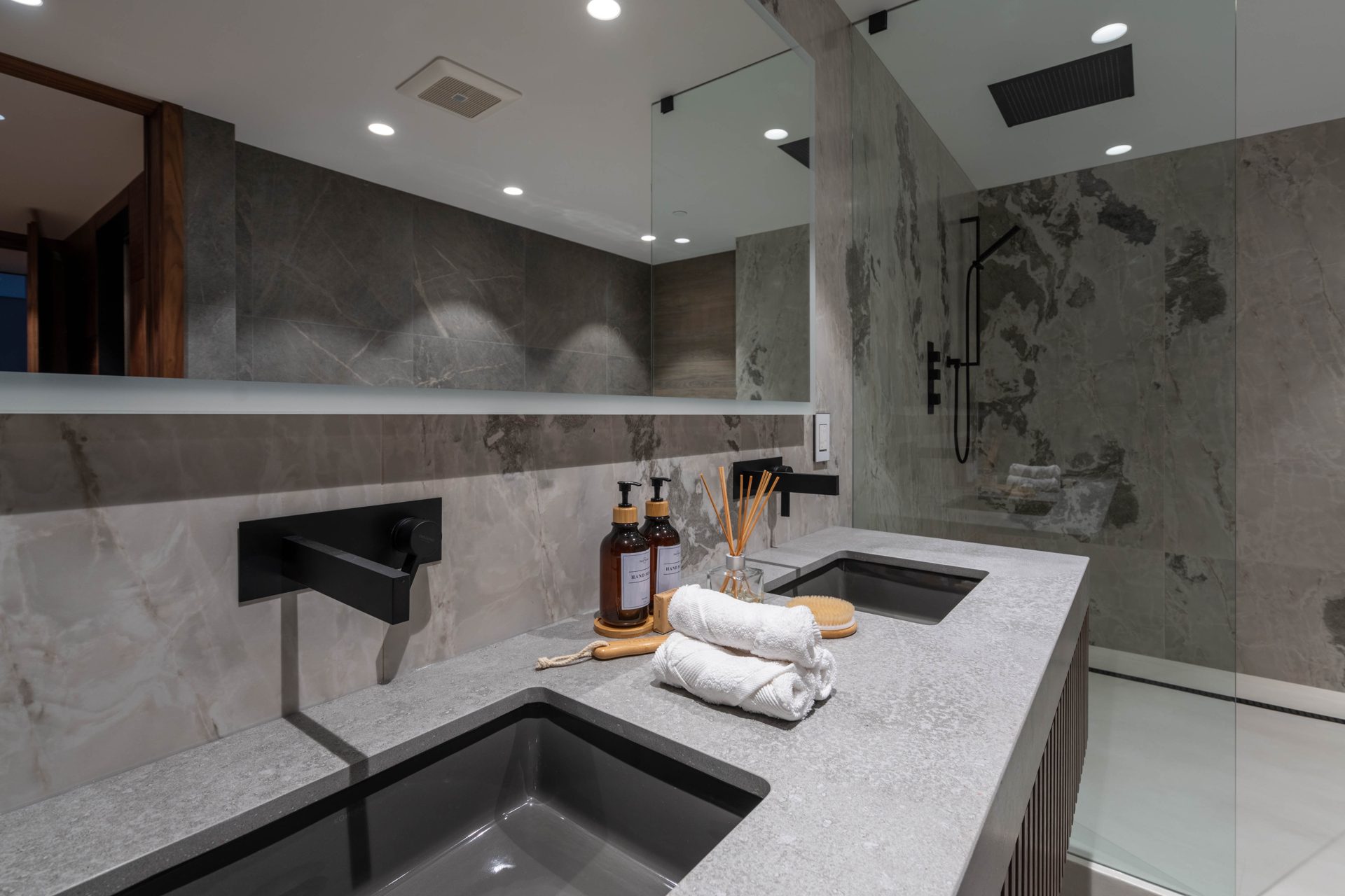 Floating stone vanity with an integrated sink and wall-mounted faucet, Toronto ensuite