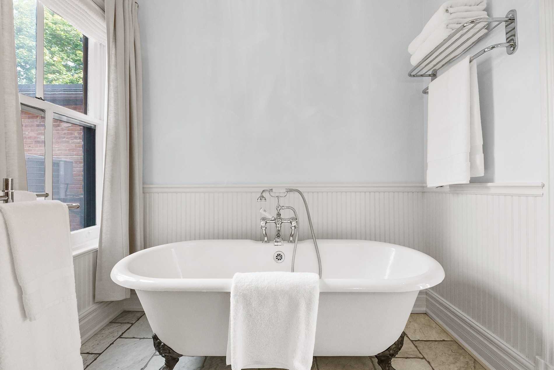 Clawfoot tub with a chrome telephone faucet and beadboard wainscoting, Toronto