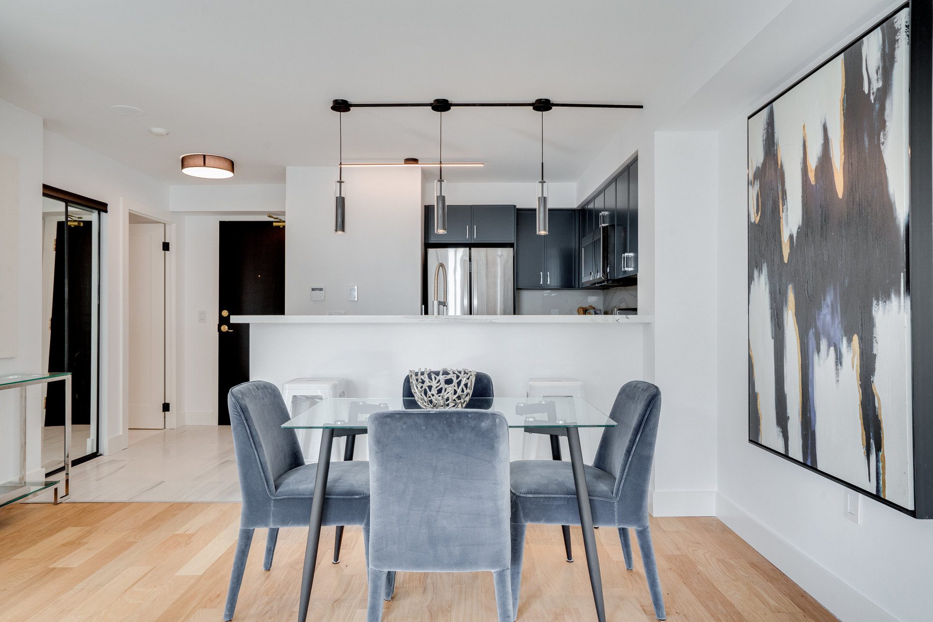 Condo kitchen with navy cabinets, breakfast bar and pendant lighting over the dining area, Etobicoke