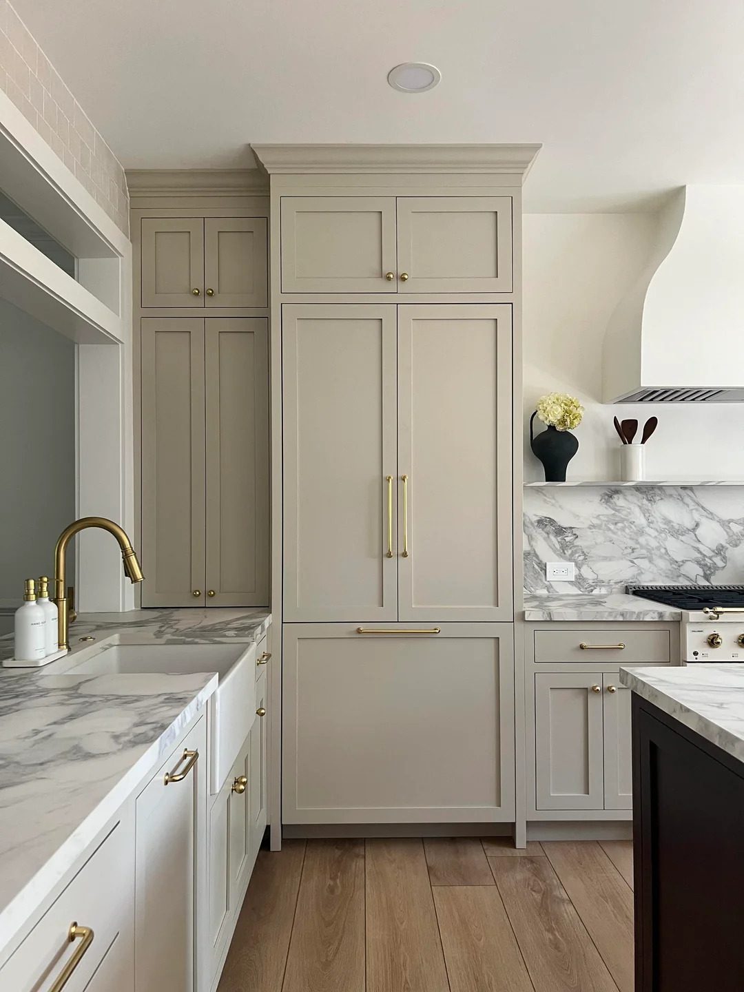 Taupe shaker kitchen with panelled fridge, marble backsplash and brass hardware, Annex, Toronto