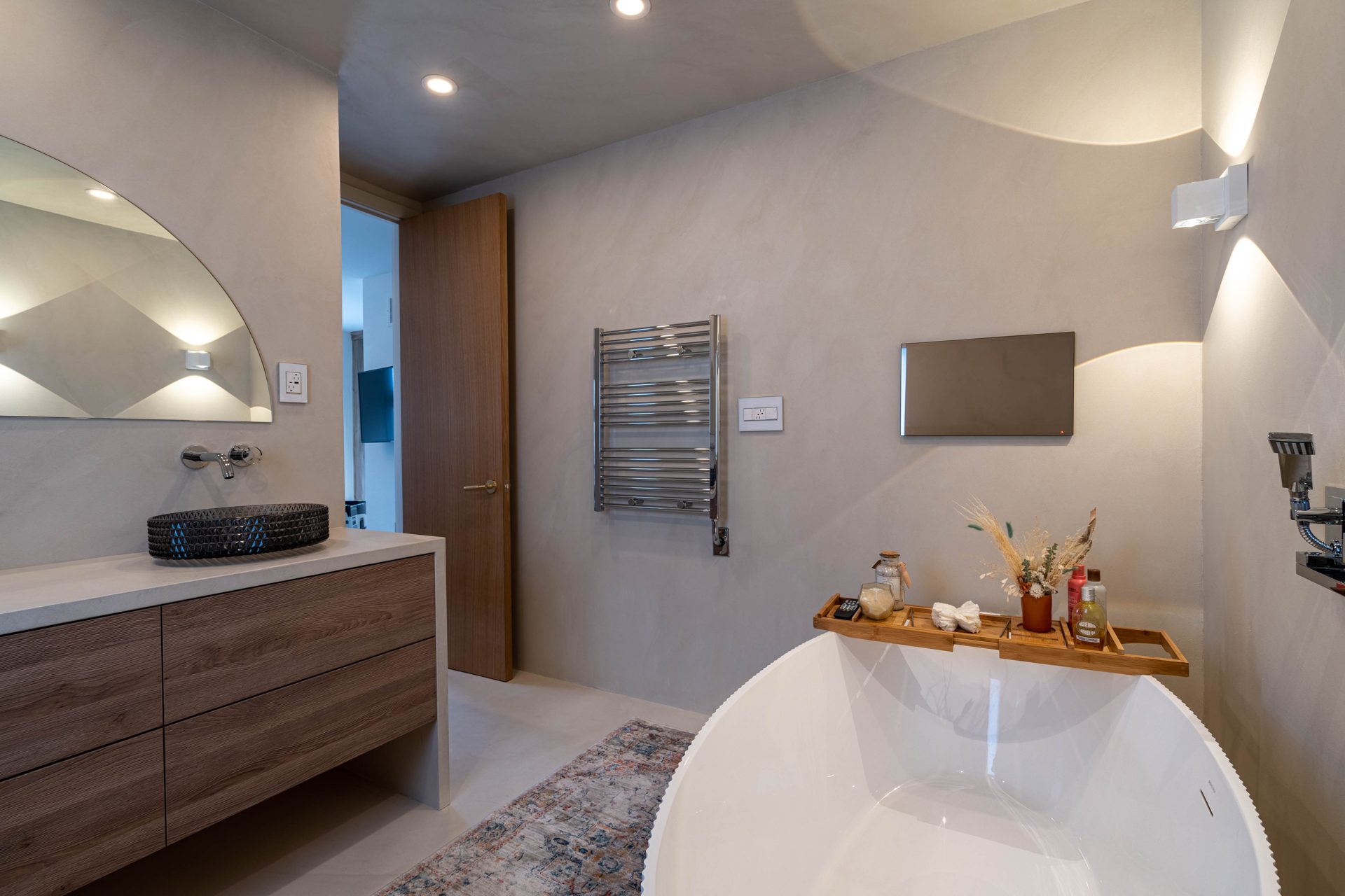 Seamless micro cement ensuite with freestanding tub and floating oak vanity from a bathroom renovation in Richmond Hill